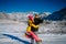 Attractive people having fun on the background of snow-capped peaks. Couple in love dressed in bright clothing hugs against snow