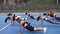 Attractive picture of seven athletic lean women which doing fitness exercises on the sportground on the park background