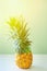 Attractive pineapple on the table against mint background.Tropical summer vacation concept, healthy food, wellbeing.
