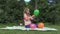 Attractive pregnant woman girl blow colorful balloons in garden