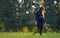 Attractive pregnant woman with long hair, in dress standing on grass in summer park. 9 months pregnancy. Expecting child