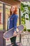 Attractive redhead female holds Longboard.