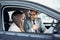 Attractive saleswoman showing inside of a car to customer.