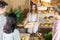 An attractive saleswoman shows a cracked loaf of bread to her customers in a woven basket. Family bakery shop with multi