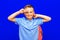 Attractive schoolboy with backpack on the blue background shows a sign V. back to school in second grade