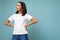 Attractive self-confident arrogant young brunette woman in casual white t-shirt for mockup isolated on blue background