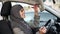 Attractive self-confident Muslim lady applying lipstick sitting in car, coquette