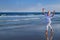 Attractive senior grey haired woman dancing near sea shore