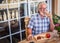 Attractive senior man with white hair and colored eyeglasses eating a sandwich with salami together with a red wine glass. Relaxed