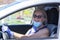 Attractive senior woman takes off the surgical mask due to coronavirus and smiles driving the car in sunny day