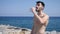 Attractive shirtless muscleman on the beach drinking water