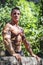 Attractive shirtless young muscleman outdoors in nature