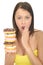 Attractive Shocked Natural Young Woman Holding a Pile of Iced Donuts