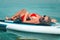 Attractive slim Caucasian woman lies on a surfboard in a red swimsuit and sunglasses. Young woman sunbathing on a