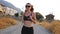 Attractive slim girl jogging through country road. Sporty woman in sunglasses working out outdoor at early morning