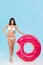 attractive slim girl posing with inflatable donut ring,