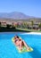Attractive slim young woman lying on inflatable sunbed on swimming pool