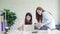 Attractive smart creative Asian business women in smart casual wear working on laptop while sitting on desk on office desk.