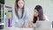 Attractive smart creative Asian business women in smart casual wear working on laptop while sitting on desk on office desk.