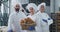 Attractive smiling beautiful bakers in a bakery kitchen industry portrait looking straight to the camera and enjoying