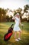 Attractive smiling positive golfer girl in gear clings to the cap. Waiting for a good game of golf. Golf Club