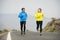 Attractive sport couple man and woman running together on asphalt road mountain landscape