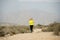 Attractive sport woman running on earth trail dirty road with desert mountain landscape background