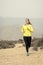 Attractive sport woman running on earth trail dirty road with desert mountain landscape background