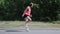 Attractive sportive girl dancing in park. Young girl performing ridiculous dance and fooling around. Cute girl in pink shirt laugh