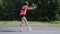 Attractive sportive girl dancing in park. Young girl performing ridiculous dance and fooling around. Cute girl in pink shirt laugh