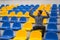 Attractive sporty young man model in blue shirt sitting on blue stadium seats after training staring at field