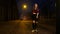 Attractive teen girl in skirt dancing and having fun on a night street.