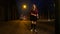 Attractive teen girl in skirt dancing and having fun on a night street.