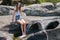 Attractive teenage girl sitting on rock ledge with legs splashing cool water