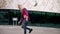 Attractive teenage girl stepping on skateboard and rolling on wide space area. Teenager skating on concrete square and