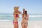 Attractive teenagers standing in front of the sea in beachwear