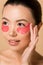 Attractive tender asian woman with pink collagen eye pads