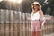 Attractive, tender and romantic smiling girl with long loose blonde hair in a straw hat is walking outside on the sunset. Countrys