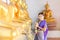 Attractive Thai woman in an ancient Thai dress holds a garland of fresh flowers paying homage to Buddha to make a wish on the