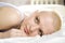 Attractive thoughtful blond bald woman lying