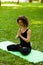 Attractive and tranquil woman sits in lotus position under tree. Yoga and meditation, concentration and relaxation, unity with