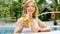 Attractive travel woman in white swimsuit lounging by outdoor pool