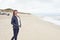 Attractive trendy woman walking on a deserted sandy beach