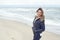 Attractive trendy woman walking on a deserted sandy beach