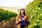 Attractive winemaker woman holding a glass of red wine in her hand and looking at the camera