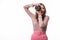 Attractive woman aims her camera composing a photograph in studio, isolated on white background