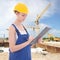 Attractive woman builder writing something in clipboard