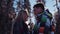 Attractive woman in a colorful winter outfit and handsome young man in green ski-costume. Gorgeous woman standing by the