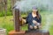 Attractive woman cooking over a picnic BBQ