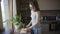 Attractive woman cutting orange standing in kitchen